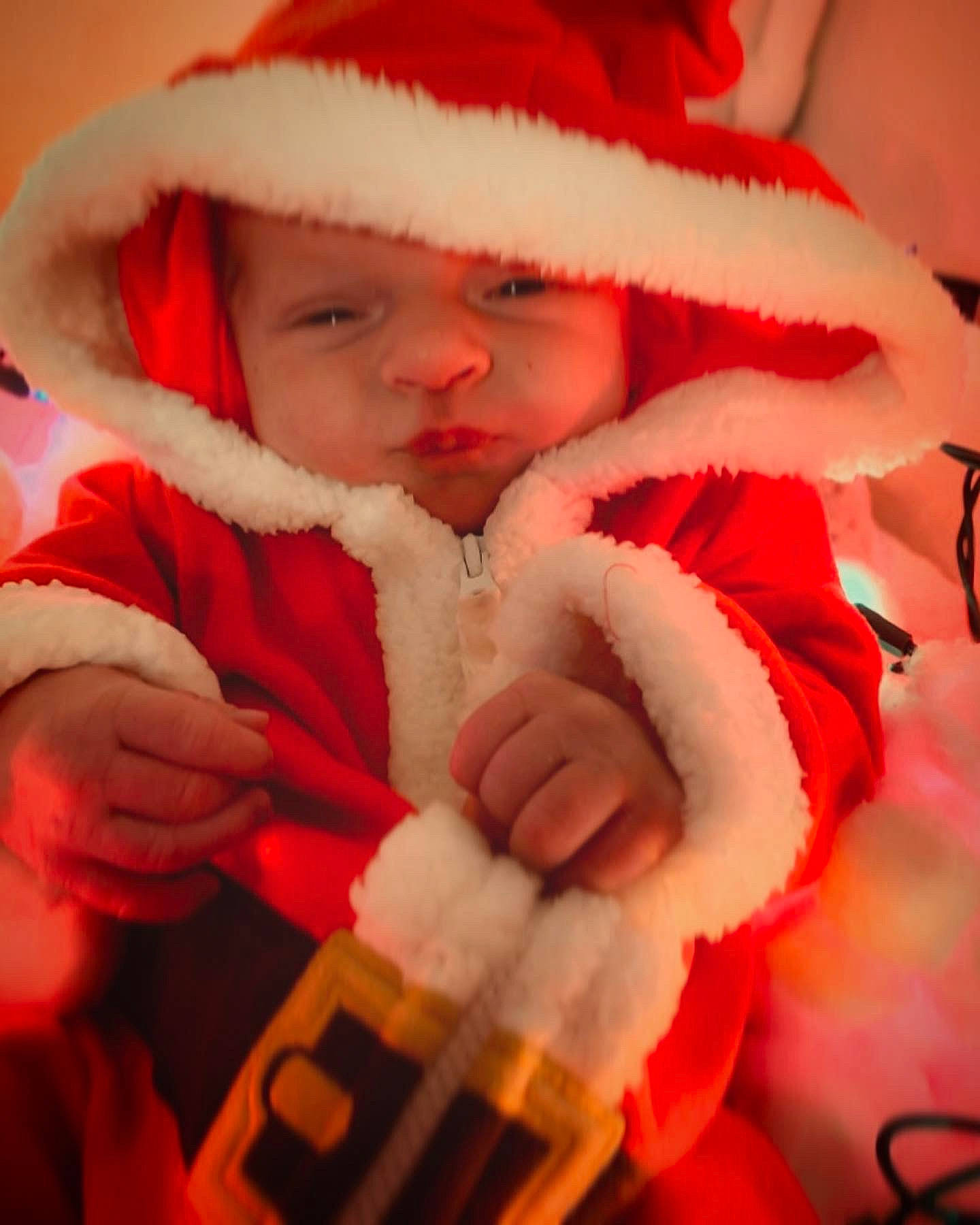 Waylon joined the competition — help win amazing prizes! baby, comfort, event, finger, fun, fur, fur_clothing, gesture, hand, happy, hat, headwear, holiday, jacket, lip, person, red, santa_claus, smile, thumb