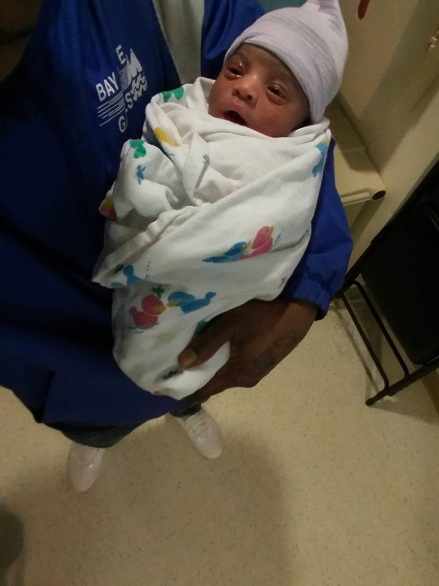 Genesis is registered to the contest to win money with this photo: baby, baby_products, baby_safety, baby_toddler_clothing, cap, child, comfort, flooring, hat, headwear, linens, person, sitting, sleeve, toddler