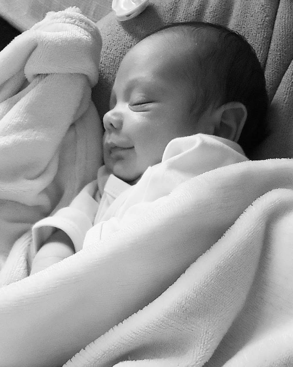 Lyam a rejoint le concours — aidez-le/la à gagner de superbes lots ! baby, bedtime, black, child, close_up, comfort, event, face, finger, gesture, happy, linens, monochrome, monochrome_photography, person, sitting, skin, smile, stock_photography, thumb