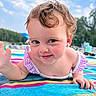 toddler, child, baby, curly_hair, blue_eyes, smiling, beach, towel, outdoor, summer, sunny, playful, cute, skin, portrait, waving, colorful, striped, nature, daytime