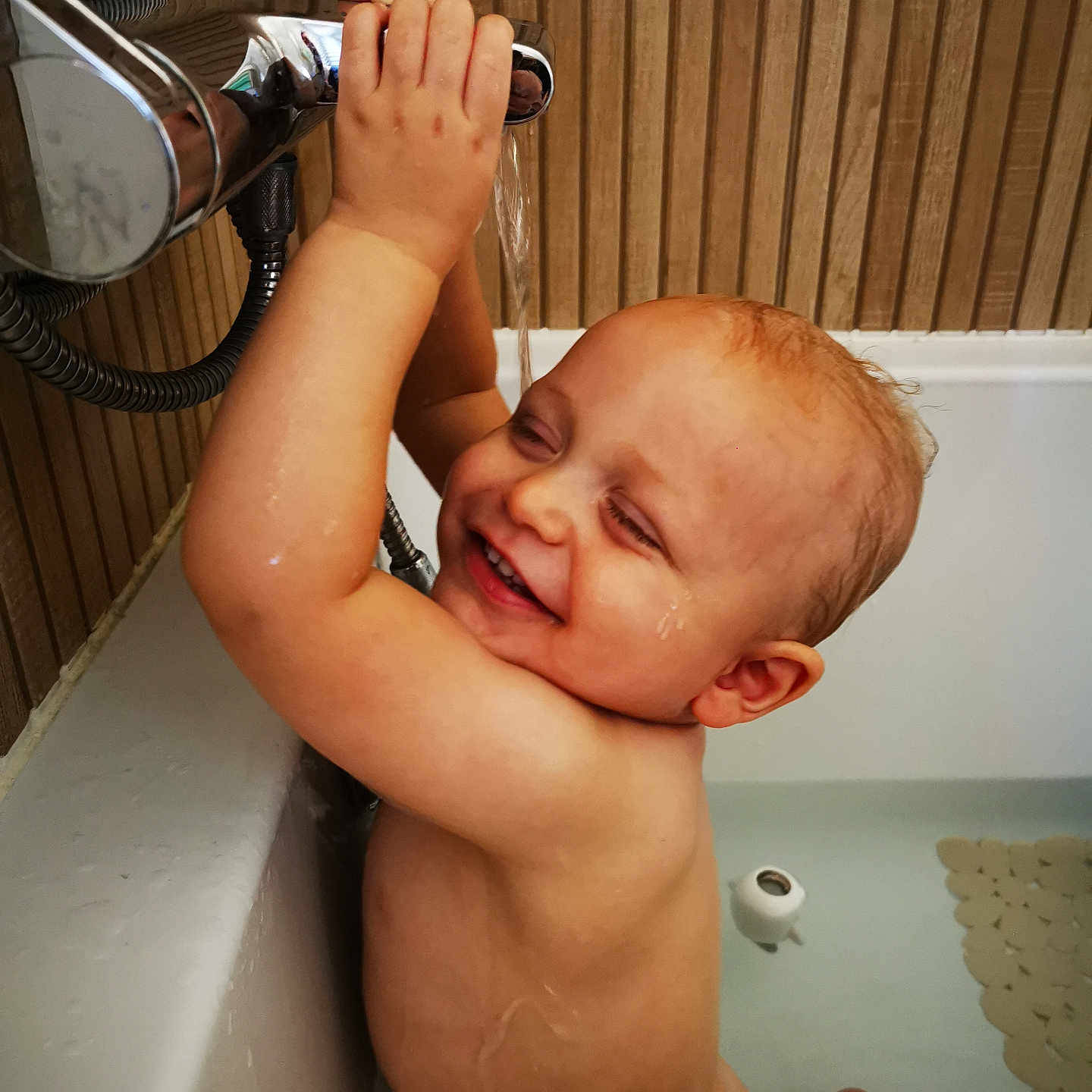 Louis participe au concours pour gagner de l'argent avec cette photo : arm, bath, bathroom, bathtub, child, closeup, faucet, fun, hand, happy, head, indoors, playing, plumbing, skin, smiling, toddler, wall, water, wet