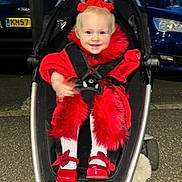 Maya-Lilly is registered to the contest to win money with this photo: toddler, child, smiling, stroller, red_clothing, red_shoes, fur_trim, pigtails, outdoor, evening, car, parking_lot, asphalt, person, baby, cute, happy, fashion, portrait, seatbelt