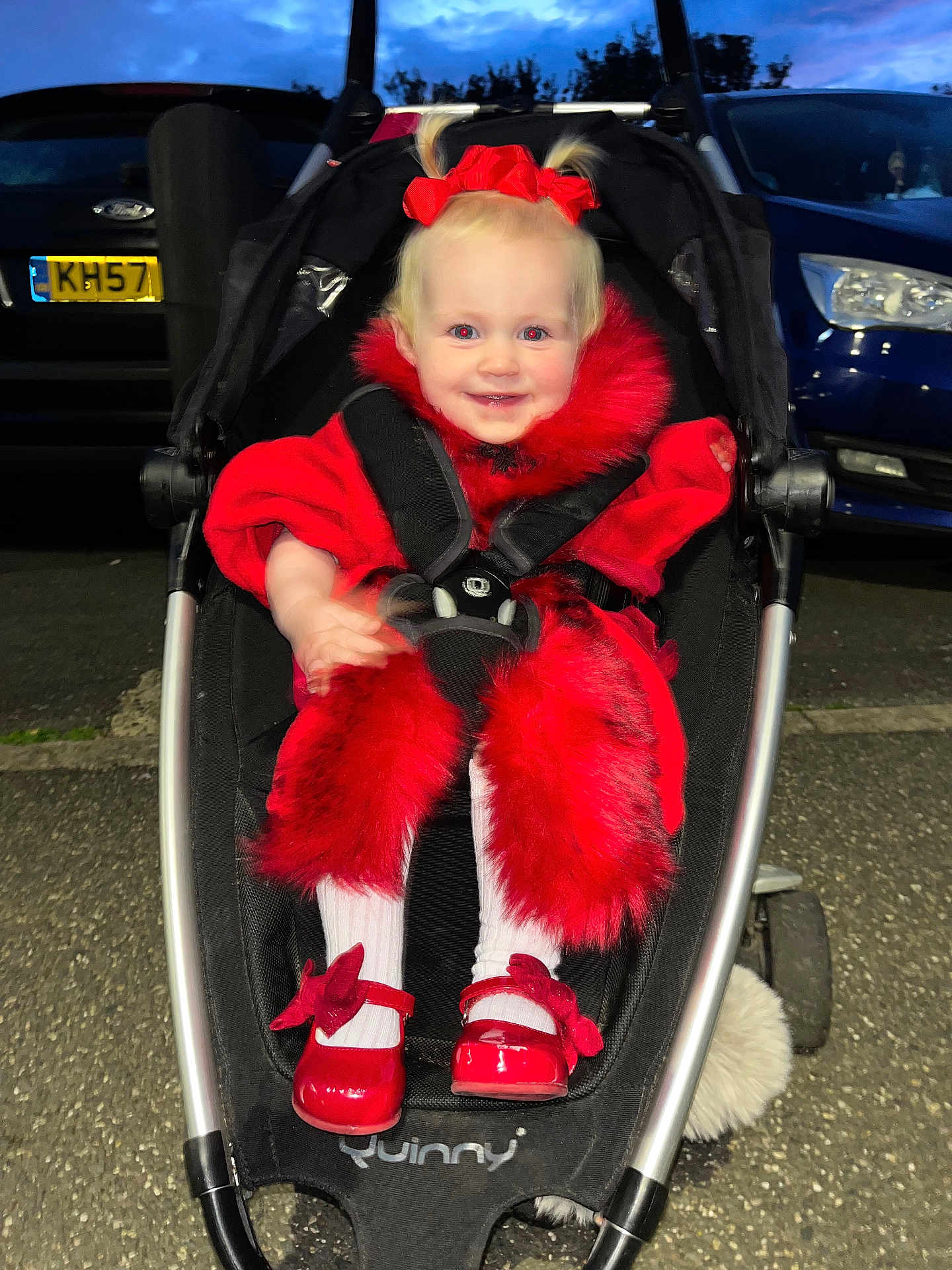 Maya-Lilly is registered to the contest to win money with this photo: toddler, child, smiling, stroller, red_clothing, red_shoes, fur_trim, pigtails, outdoor, evening, car, parking_lot, asphalt, person, baby, cute, happy, fashion, portrait, seatbelt