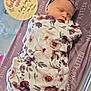 newborn, baby, sleeping, blanket, headband, floral_pattern, purple, personalized, crib, sign, text, wooden, birth_details, peaceful, indoors, infant, swaddled, cute, resting, portrait
