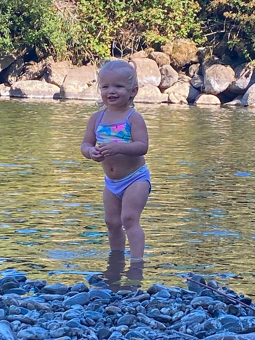 Samantha is registered to the contest to win money with this photo: azure, blue, electric_blue, fun, happy, joy, lake, leisure, people_in_nature, person, plant, recreation, rock, smile, stream, summer, swimwear, thigh, toddler, water
