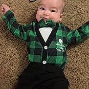 Ashton joined the competition — help win amazing prizes! baby, infant, carpet, green_clothing, bow_tie, black_pants, smiling, happy, lying_down, cute, child, toddler, indoor, floor, plaid, clothing, person, hair_tie, celebration, cheerful