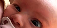 Lou participe au concours pour gagner de l'argent avec cette photo : baby, pacifier, infant, face, close_up, child, cute, skin, person, newborn, mouth, head, expression, eyes, human, young, holding, comfort, soft, indoor
