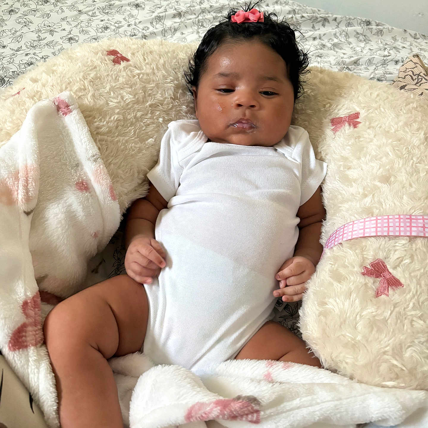 Milove joined the competition — help win amazing prizes! baby, bed, blanket, child, comfort, cute, drool, floral_bedspread, foot, hand, indoors, infant, pillow, pink_bow, portrait, relaxed, resting, skin, soft_texture, white_onesie