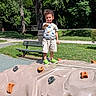 Jaydence is registered to the contest to win money with this photo: bench, boy, bridge, casual_clothing, child, climbing_holds, climbing_wall, grass, outdoor, park, path, playground, portrait, rock_climbing, smiling, sportswear, standing, sunny, thumbs_up, trees
