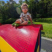 Jaydence joined the competition — help win amazing prizes! blue_sky, boy, child, clouds, forest, grass, happy, outdoor, park, play, play_equipment, playground, portrait, red, sitting, summer, sunlight, toddler, trees, yellow