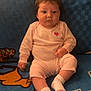 Alivia Isaac is registered to the contest to win money with this photo: baby, infant, child, pink_clothing, onesie, socks, pacifier, ponytail, blue_blanket, cartoon_pattern, indoor, seated, cute, chubby_cheeks, expressionless, soft_lighting, wooden_wall, homedecor, portrait, toddler