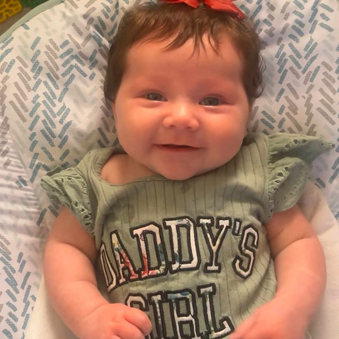 Alivia Isaac joined the competition — help win amazing prizes! baby, bow, child, clothing, cute, daddys_girl, face, green_shirt, hand, happy, head, indoor, infant, patterned_seat, person, portrait, sitting, smiling, text, young_child