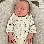 Cameron participe au concours pour gagner de l'argent avec cette photo : baby, newborn, sleeping, onesie, dog_prints, blanket, plush_toys, cushion, soft_fabric, infant, peaceful, cute, bed, child, resting, indoor, portrait, cozy, small_hands, nursery