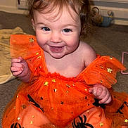 Averie-Grace joined the competition — help win amazing prizes! toddler, child, orange_dress, spiders, stars, smiling, happy, indoor, carpet, toy, radiator, cute, sitting, baby, face, person, clothing, legs, hands, curly_hair