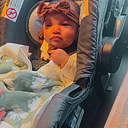 Soraya is registered to the contest to win money with this photo: baby, blanket, bow, car_interior, car_seat, child, clothing, cute, face, hand, headband, indoors, infant, person, portrait, seat_belt, sitting, soft_fabric, warm_light, young_child