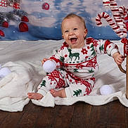 Jade participe au concours pour gagner de l'argent avec cette photo : baby, blanket, candy_cane, cheerful, child, christmas, cute, decorations, festive, gift_box, happy, holiday, indoors, pajamas, portrait, seasonal, smiling, snowballs, toddler, wooden_floor