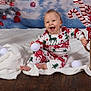 baby, blanket, candy_cane, cheerful, child, christmas, cute, decorations, festive, gift_box, happy, holiday, indoors, pajamas, portrait, seasonal, smiling, snowballs, toddler, wooden_floor