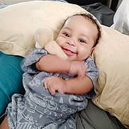 Tru joined the competition — help win amazing prizes! baby, infant, smiling_baby, smile, plush_toy, stuffed_animal, pillow, blanket, bed, onesie, arm_motion, chubby_cheeks, bright_eyes, indoor, portrait, happy, cozy, fabric_pattern, hand, candid