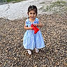 Amelia is registered to the contest to win money with this photo: child, girl, toddler, portrait, smiling, outdoor, dress, blue_dress, bows, red_shoe, shoes, standing, pebbles, gravel, yard, garden, greenery, playful, fashion, daylight