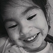 Amelia is registered to the contest to win money with this photo: child, smiling, portrait, close_up, black_and_white, face, head, hair, eyes, teeth, happy, indoors, casual, shirt, patterned_clothing, candid, looking_at_camera, young, person, photography