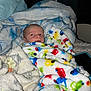 Salem is registered to the contest to win money with this photo: baby, blanket, colorful, cozy, face, infant, indoors, patterned_blanket, soft, sleeping_area, wrapped, cute, child, bed, pacifier, phone, window, curtains, resting, warm