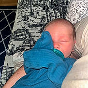 Salem is registered to the contest to win money with this photo: baby, newborn, pacifier, sleeping, blanket, blue, arm, comfort, indoor, person, human, rest, peaceful, soft, cozy, pattern, fabric, closeup, cute, portrait