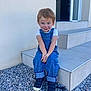 Sasha a rejoint le concours — aidez-le/la à gagner de superbes lots ! child, face_paint, tiger_face, denim_overalls, white_tshirt, black_sneakers, gravel, steps, outdoor, smiling, cute, young_child, casual_clothing, sitting, playful, daylight, curly_hair, wall, portrait, happy