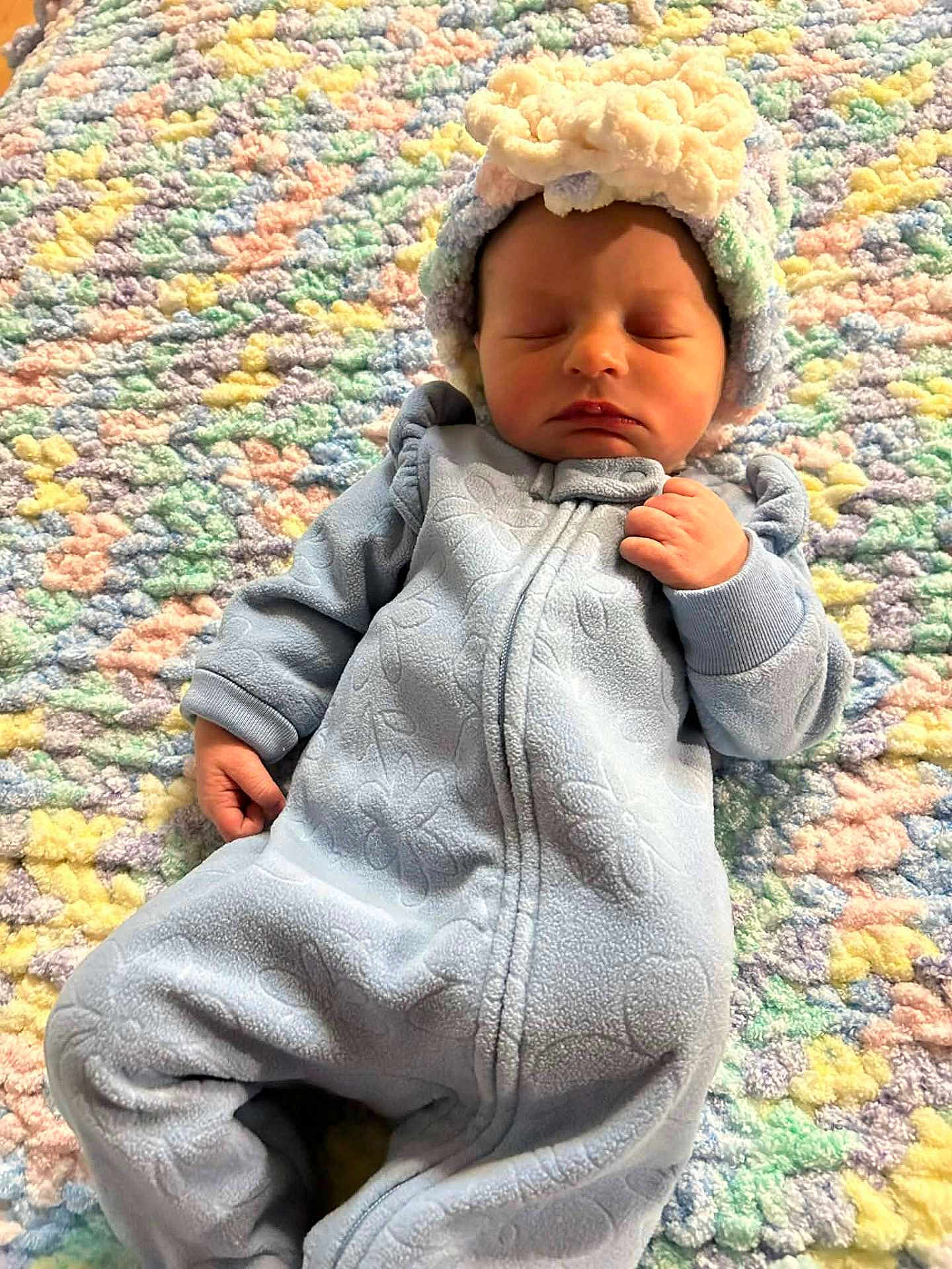 Everly is registered to the contest to win money with this photo: baby, sleeping, onesie, hat, blanket, colorful, pastel, soft, cute, infant, child, cozy, texture, lying_down, peaceful, indoors, portrait, warm, newborn, resting