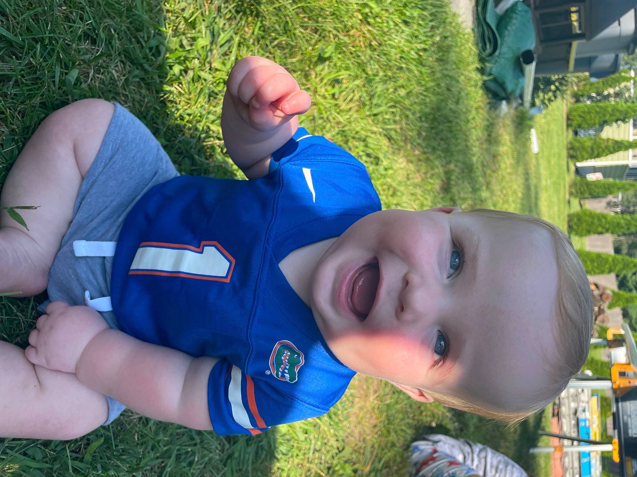 Gannon is registered to the contest to win money with this photo: cool, electric_blue, fun, grass, green, happy, hat, headgear, lawn, leisure, mouth, people_in_nature, person, personal_protective_equipment, plant, recreation, shorts, t_shirt, thigh, toddler