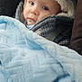baby, child, blanket, blue_blanket, hooded_jacket, gray_jacket, car_seat, face, portrait, cozy, infant, warm_clothing, soft_texture, indoors, closeup, cute, young_child, seated, looking, wrapped