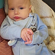 Aidan joined the competition — help win amazing prizes! baby, infant, blue_onesie, hands, blanket, couch, face, skin, person, child, cute, young, indoor, soft_texture, expression, portrait, sleepwear, comfort, resting, closeup