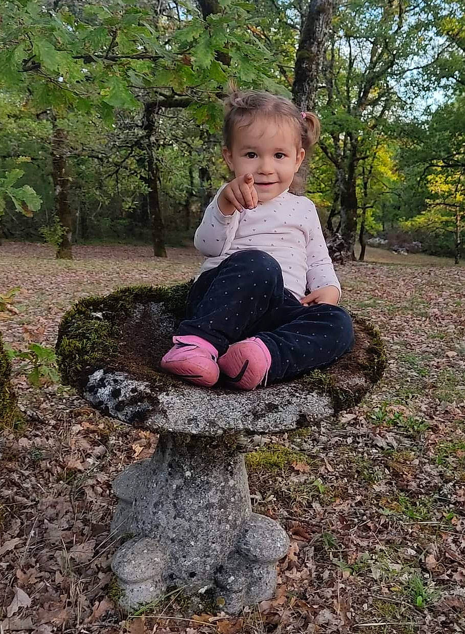 Abigaëlle a rejoint le concours — aidez-le/la à gagner de superbes lots ! baby, baby_toddler_clothing, boot, child, forest, fun, grass, happy, head, joy, landscape, people_in_nature, person, plant, sitting, smile, soil, toddler, tree, trunk