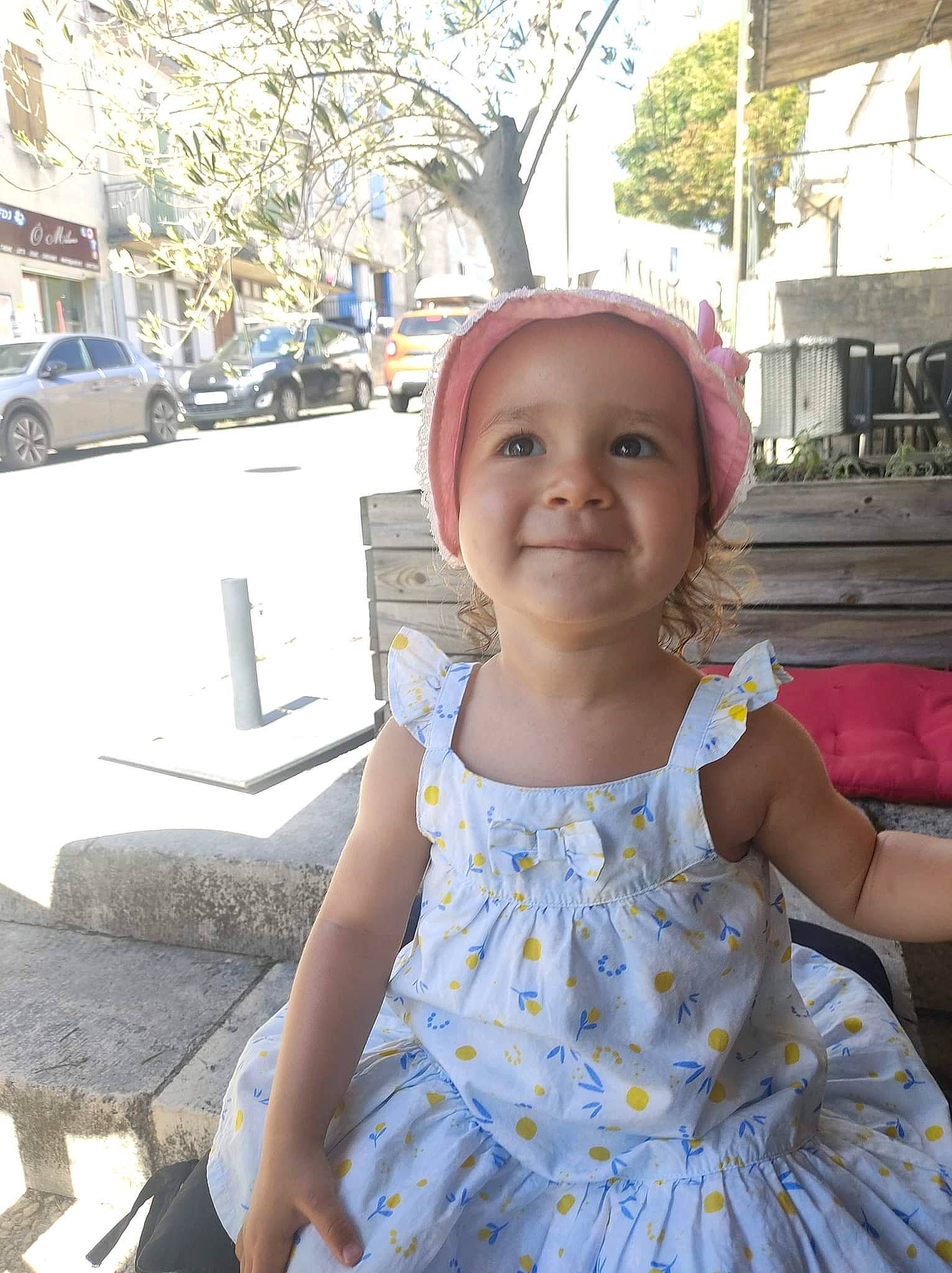 Abigaëlle participe au concours pour gagner de l'argent avec cette photo : baby_toddler_clothing, car, child, day_dress, event, fun, happy, headwear, joy, leisure, pattern, person, plant, ruffle, sitting, smile, tire, toddler, travel, tree