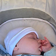 Gaberiel Samuel is registered to the contest to win money with this photo: baby, sleeping, hat, blue_clothing, truck_print, baby_carrier, cushion, peaceful, infant, face, hand, closed_eyes, soft_light, indoor, cute, child, newborn, resting, portrait, cozy