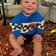 Oakley joined the competition — help win amazing prizes! baby, child, sitting, smiling, blue_sweatshirt, mickey_mouse, carpet, rug, indoor, toy, furniture, couch, happy, cute, person, foot, hand, home, patterned_rug, cozy