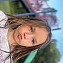 blue_eyes, casual_clothing, child, daylight, expression, face, freckles, fun, girl, long_hair, nature, outdoor, park, playground, portrait, puckered_lips, slide, smile, trees, youth