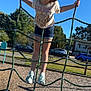 child, girl, playground, rope_net, climbing, smiling, outdoor, daylight, blue_sky, trees, grass, shoes, shorts, tshirt, happy, fun, summer, park, recreation, leisure
