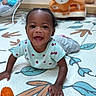 Cori is registered to the contest to win money with this photo: arms, baby, bedroom, child, clothing, curly_hair, dark_skin, face, happy, indoor, infant, ladybug_pattern, pillow, play_mat, playful, plush_toy, portrait, shirt, sitting, smiling