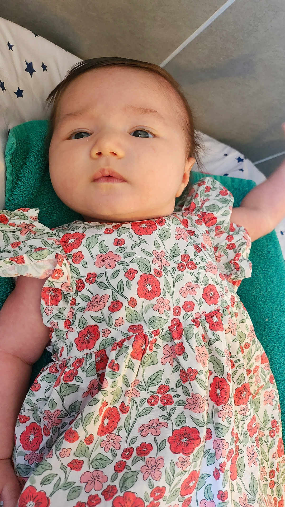 Esmée a rejoint le concours — aidez-le/la à gagner de superbes lots ! baby, child, floral_dress, patterned_clothing, infant, lying_down, blanket, stars_pattern, soft_towel, portrait, cute, face, skin, arm, indoor, young, person, expression, comfort, calm