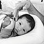 baby, newborn, infant, hand, adult_hand, black_and_white, portrait, sleeping, closeup, face, expression, cushion, blanket, soft, resting, peaceful, clothing, cute, human, tender