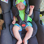 Esmée a rejoint le concours — aidez-le/la à gagner de superbes lots ! baby, car_seat, sleeping, headband, green_outfit, infant, child, safety_harness, wooden_floor, indoors, peaceful, cute, small_hands, small_feet, soft_skin, black_car_seat, resting, adorable, toddler, childcare