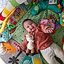 baby, smiling, playmat, plush_toy, deer, soft_toys, child, indoor, colorful, happy, infant, lying_down, cute, clothing, toddler, toy, face, person, baby_play_area, cushion