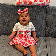 Leilanii is registered to the contest to win money with this photo: baby, child, smiling, sitting, couch, blanket, headband, bow, strawberry, skirt, shirt, happy, indoor, clothing, cute, portrait, infant, patterned, wall, furniture