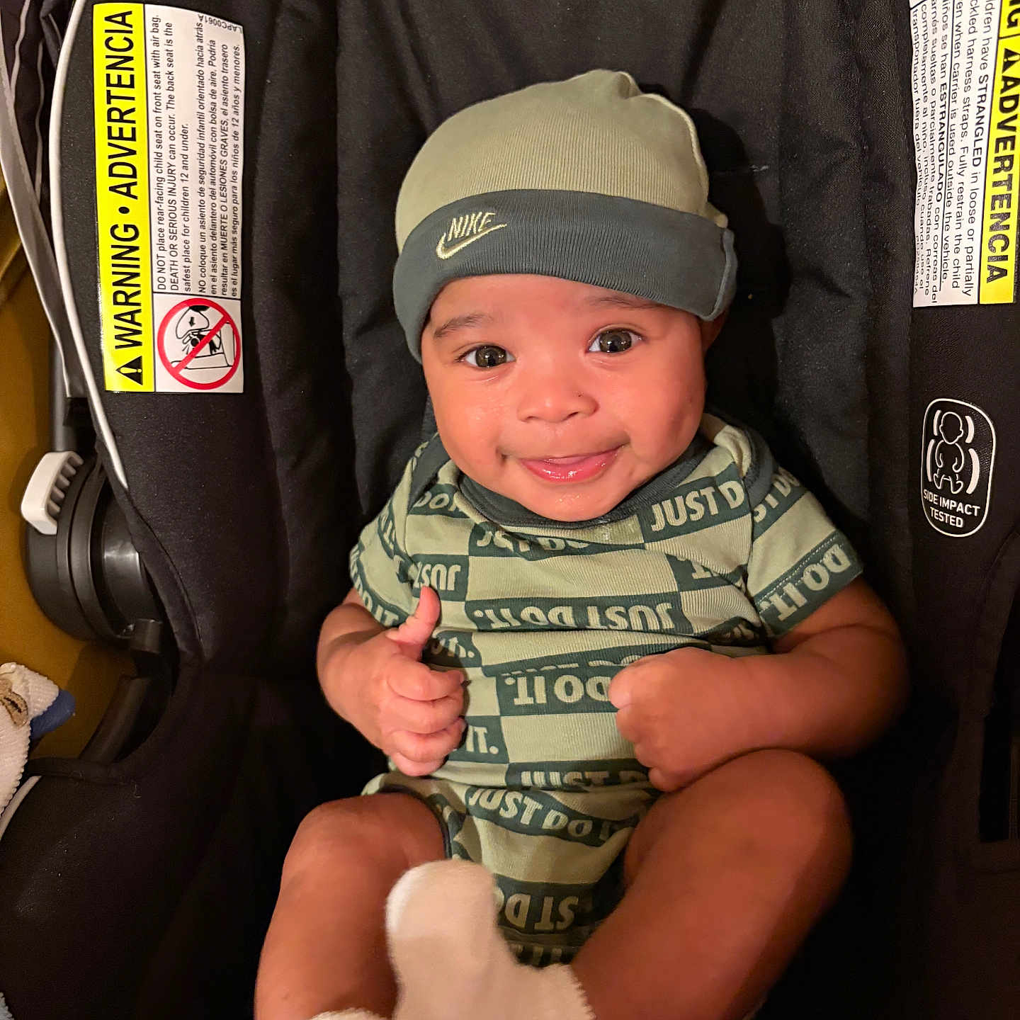 Pablo is registered to the contest to win money with this photo: apparel, baby, beanie, car_seat, child, cute, green_clothing, happy, indoors, infant, infant_accessories, infant_clothing, nike, person, portrait, seat, sitting, smiling, socks, thumbs_up