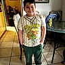 James joined the competition — help win amazing prizes! child, boy, smiling, portrait, standing, indoors, home, t_shirt, baseball_shirt, cartoon, ninja_turtles, green_pants, shoes, dining_room, table, chairs, tiled_floor, toy, framed_certificate, photography