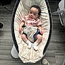 Ayden is registered to the contest to win money with this photo: baby, infant, child, rocker, cushion, striped_shirt, white_socks, curly_hair, indoor, flooring, footwear, person, seat, baby_gear, relaxing, looking, cute, young_child, modern, comfortable