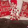 Delylah Rose is registered to the contest to win money with this photo: baby, blanket, child, couch, cozy, cute, decoration, fabric, happy, headwear, heart_pattern, indoor, infant, love_theme, pillow, portrait, red_bow, sitting, smiling, valentines_day