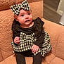 Delylah Rose is registered to the contest to win money with this photo: baby, black_clothing, bow, chair, child, cozy, curious_expression, cute, floor, footwear, headband, houndstooth, indoor, infant, long_sleeves, outfit, person, portrait, sitting, sparkles