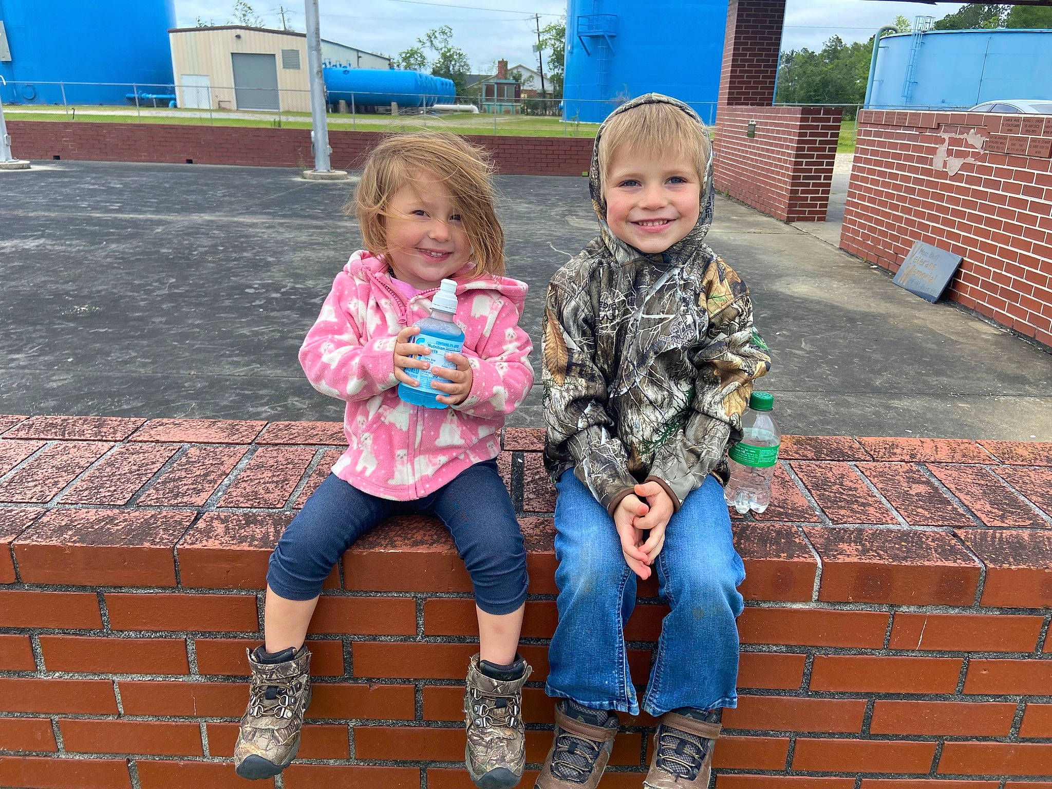 Joycelynn is registered to the contest to win money with this photo: blue, brick, brickwork, child, electric_blue, fun, grass, happy, jeans, joy, leisure, pattern, person, pink, recreation, shoe, sitting, smile, sneakers, toddler