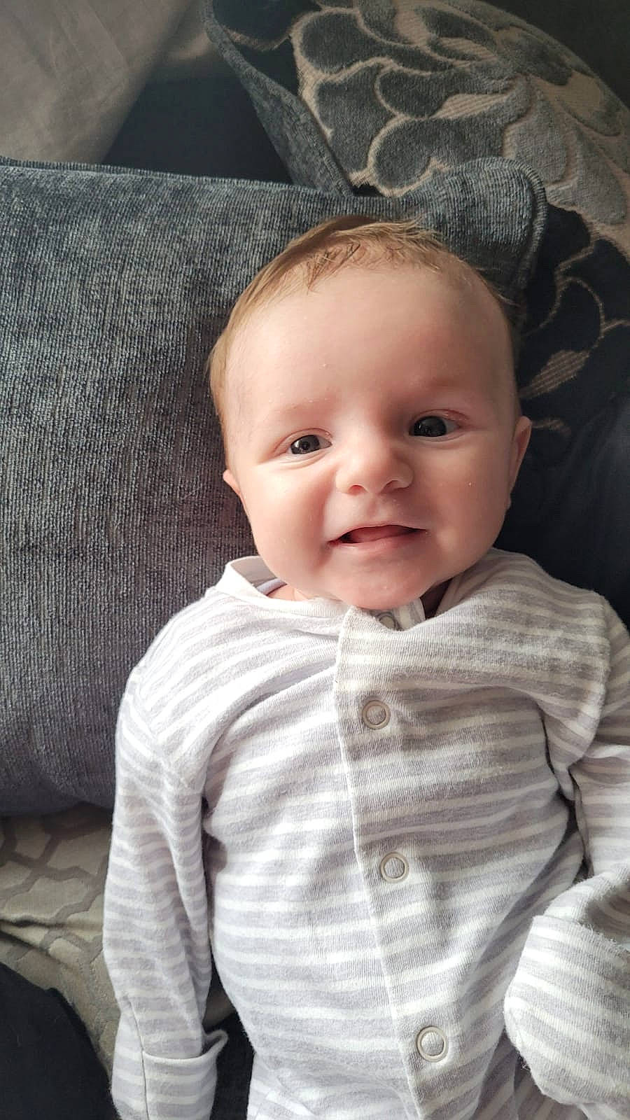 Jenson is registered to the contest to win money with this photo: baby, baby_toddler_clothing, cheek, chin, comfort, eyebrow, face, facial_expression, flash_photography, grey, hairstyle, iris, lip, outerwear, person, skin, sleeve, smile, standing, textile